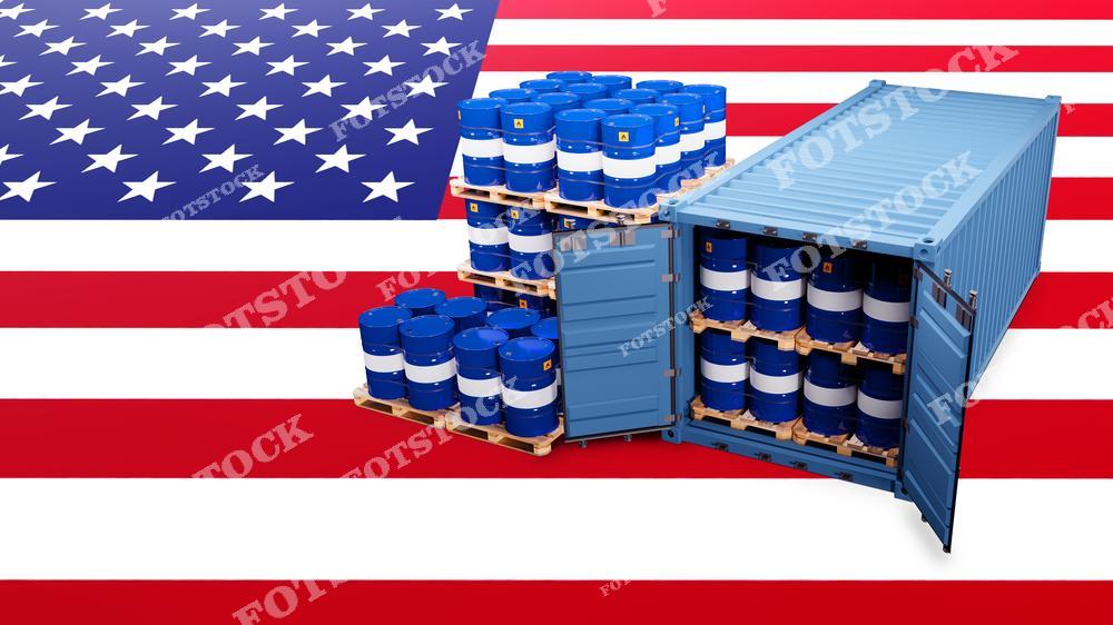 Открытый контейнер, заполненный бочками с нефтью, расположен на фоне флага США. Фотография подчеркивает значимость нефтяной логистики и роль импорта и экспорта нефти в экономике США.